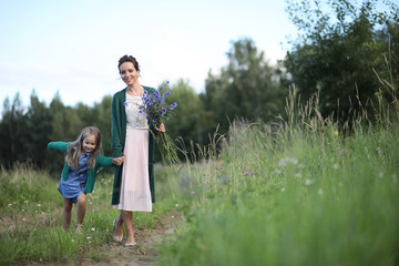 Fototapeta premium Mother with daughter walking on a road