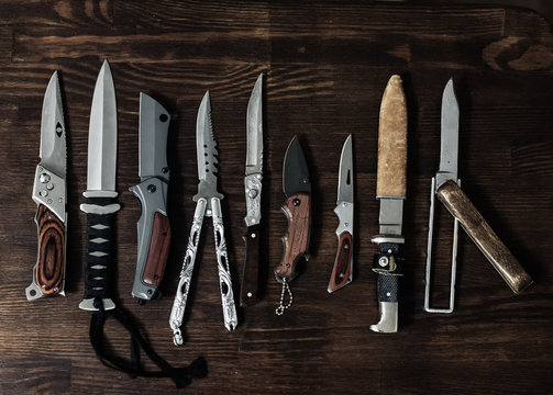 many different knives on a wooden surface