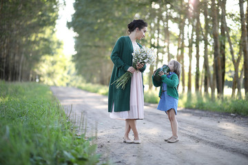 Fototapeta premium Mother with daughter walking on a road