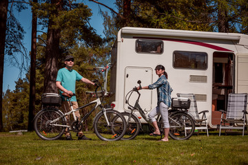 Woman with a man on electric bike resting at the campsite.