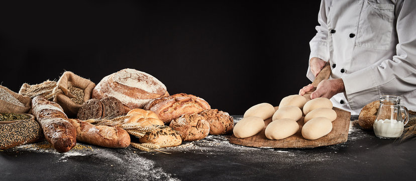 Baker holding a wooden paddle with formed dough