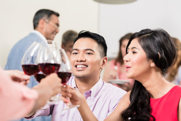 Couple toasting wineglasses with friends