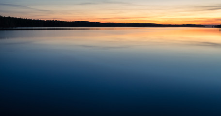 Scenic dawn landscape with lake after sunset at spring evening in Finland