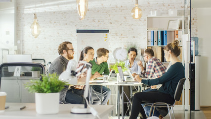 Seven Stylish People Having Planning Business Session Sitting at Big Table in their Bright Modern Creative Office.