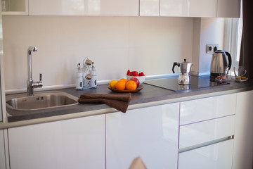 White contemporary kitchen with stone floor and black accessories