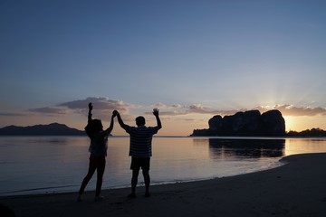 Fototapeta premium couple walking on the beach at sunset