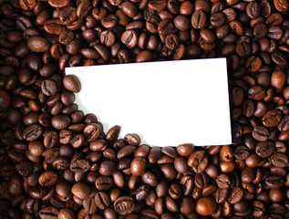 Blank white card for your text on coffee beans background close up photo