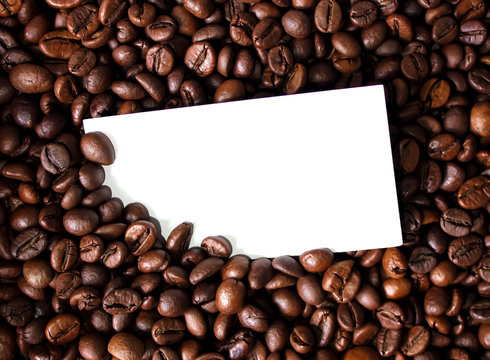 Blank white card for text on coffee beans background close up photo