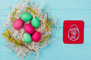 Traditionally painted Easter eggs in nest. Red paper card with drawn image of Easter egg. Easter greeting ideas for kids.