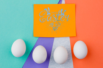 Happy Easter colorful background. Easter greeting card. Row of four white Easter eggs. Ideas of simple Easter decor.
