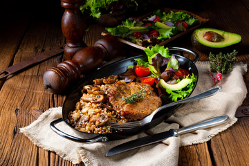 Pork steak with mushrooms and buckwheat groats and mango salad