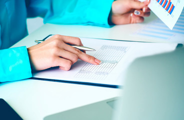 Business woman working with financial data holding sheet of paper with financial figures in hand and make notes in clipboard. Business financial and accounting concept.