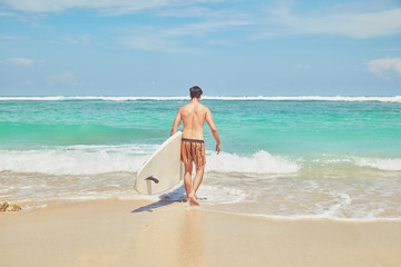 Surfer man with surfboard enjoying on the beach. Summer concept.