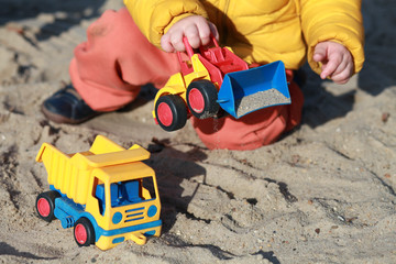 child playing with toys on the sandpit