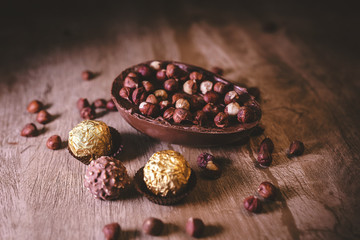 Chocolate egg with filling for Easter on wooden background