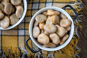 Broad beans served in black bowls.