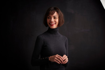 Beautiful happy woman posing at dark background