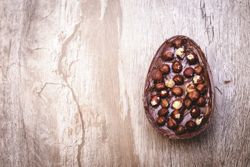 Chocolate egg with filling for Easter on wooden background