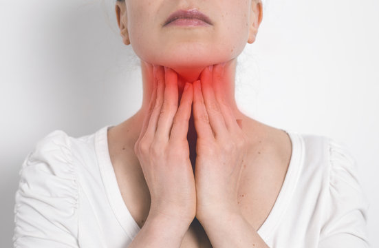 Angina. A woman holding her sore throat. Inflamed thyroid gland.