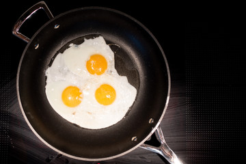 fry three fried eggs in a frying pan