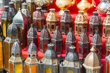 row of shiny traditional coffee pots and lamp