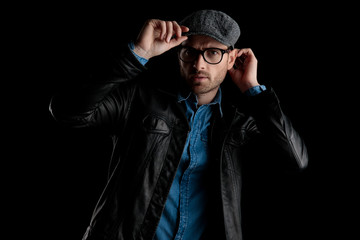 Obraz premium frown man with eyeglasses adjusting his cap