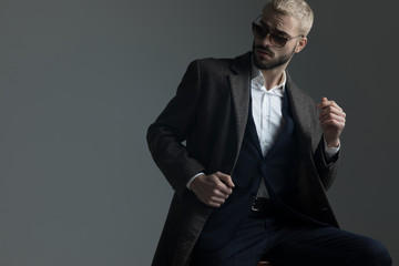 blonde guy with sunglasses adjusting his collar