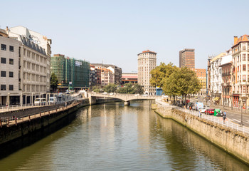 Obraz premium Bilbao, Spain-September 2018. River of the city with people in the shore. Describe the city life.