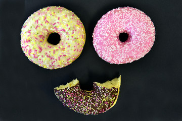 zwei bunte donuts bilden ein gesicht mit stilisiertem mund darunter