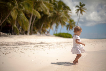 Cute little baby girl walking on the beach