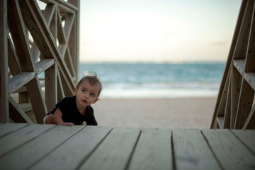 Baby climbing stairway at the beach