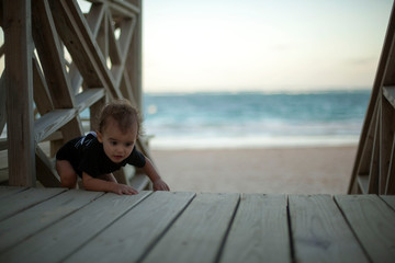 Baby climbing stairway at the beach