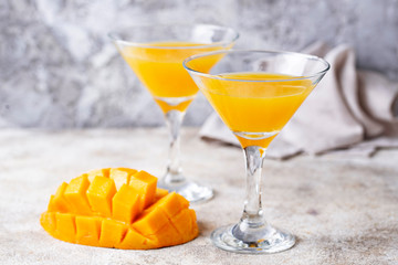 Tropical cocktail with mango on light background