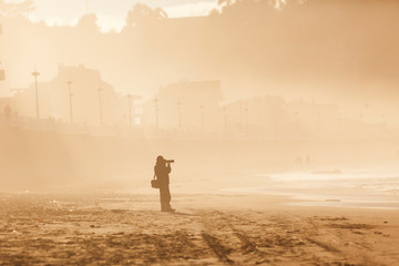 Silueta de fotógrafo en una playa al atardecer