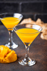 Tropical cocktail with mango on dark background