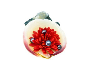 red flower with black pearls in a shell