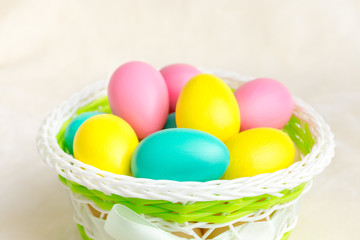 Multi-colored eggs in a green basket