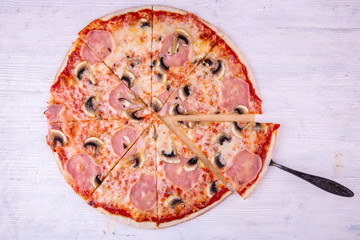 The ham and mushrooms pizza cut on several pieces