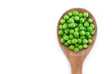 green peas on wooden spoon on white background.