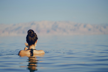 brunette girl swimming in the dead sea in israel