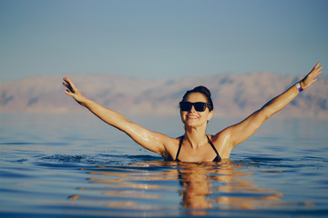 brunette girl swimming in the dead sea in israel