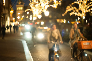 women cyclists ride down the street at night, bokeh and blur