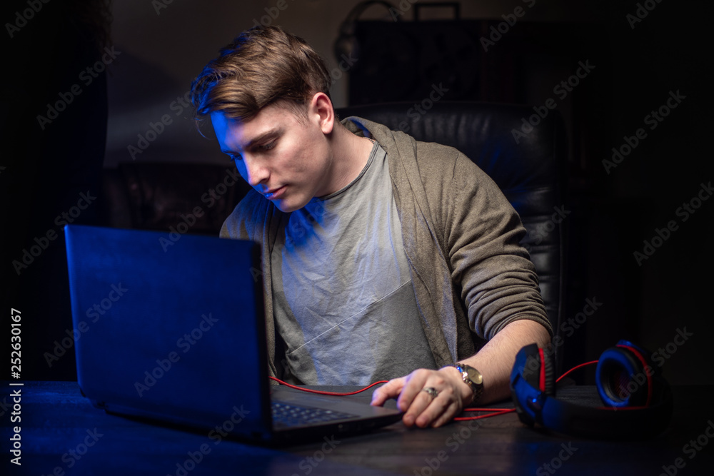 Poster hacker. a young man works at the computer. a man at the computer. hacking personal data.