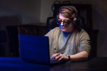 Hacker. A man at the computer. Hacking personal data. A man with glasses.