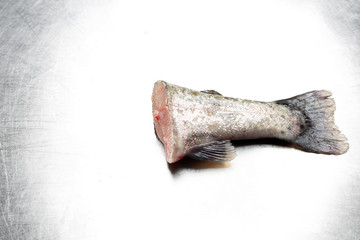 Ogon ryby. Surowy rybi ogon na srebrnym blacie © foodandcook