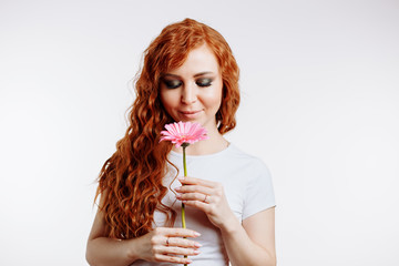 Portrait of pretty caucasian woman smelling a flower