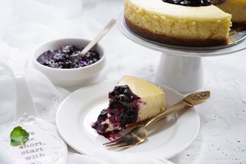 Slice of homemade cheesecake with blueberry compote topping, selective focus