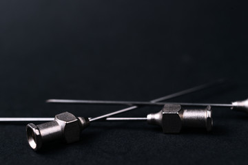 Fototapeta premium Old rare metallic medical needles isolated on gray background. Needles new and clean. Top view. Sharp needle tips and full metal body.