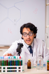 Young funny chemist in front of white board 