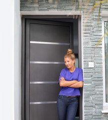 Beautiful woman opening the door of her home.Inviting the guests